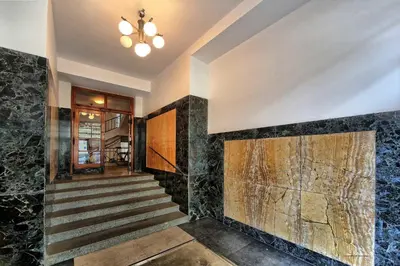 a lobby with stairs and a stone wall at Apartments Vorsilska in Prague