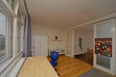 a room with a table and a blue chair at Apartments Vorsilska in Prague