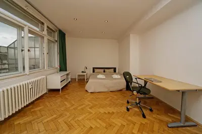 a bedroom with a bed and a desk and a desk at Apartments Vorsilska in Prague