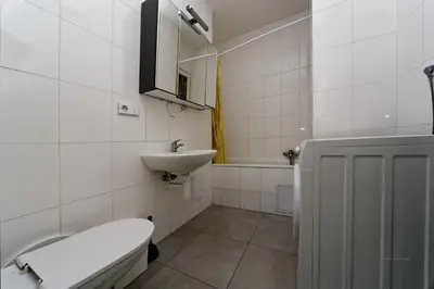 a white bathroom with a toilet and a sink at Apartments Vorsilska in Prague