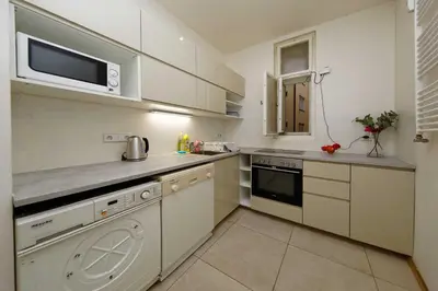 a kitchen with white cabinets and a microwave at Apartments Vorsilska in Prague