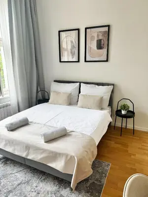 a bedroom with a large white bed with two pillows at Stylish 2BR with stunning view of National Muzeum in Prague