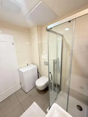 a bathroom with a toilet and a glass shower at Stylish 2BR with stunning view of National Muzeum in Prague