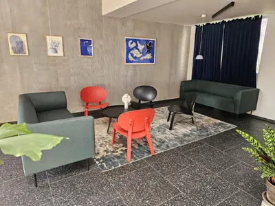 a living room with colorful chairs and a table at LIVE-INN PRAGUE 1 BDR CITY VIEW SUITE FOR 1-4 GUESTS, 20 Mins to center, Lift, Gym, Reception, Parking, Roof Terrace, Game & Party in Prague