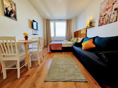 a living room with a couch and a table at LIVE-INN PRAGUE 1 BDR CITY VIEW SUITE FOR 1-4 GUESTS, 20 Mins to center, Lift, Gym, Reception, Parking, Roof Terrace, Game & Party in Prague