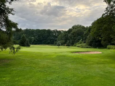 a green golf course with trees in the background at Útulný byt pár kroků od lázeňské fontány in Poděbrady