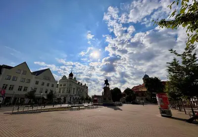 a city square with a statue in the middle at Útulný byt pár kroků od lázeňské fontány in Poděbrady
