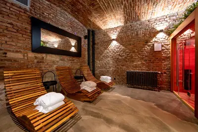 a room with two wooden chairs and a brick wall at Miss Sophie's New Town & Wellness in Prague