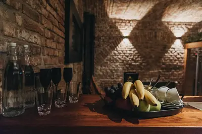 a plate of fruit on a table with wine glasses at Miss Sophie's New Town & Wellness in Prague