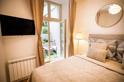 a bedroom with a bed with a mirror and a window at The Wenceslas Square Terrace in Prague