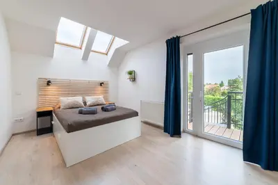a bedroom with a bed and a large window at TinyGreens B & B in Poděbrady