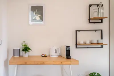 a wooden shelf on a white wall with a mirror at TinyGreens B & B in Poděbrady