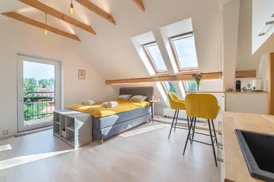 a bedroom with a bed and a table and chairs at TinyGreens B & B in Poděbrady