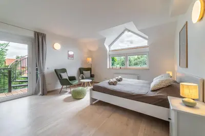a bedroom with a bed and two chairs and a window at TinyGreens B & B in Poděbrady