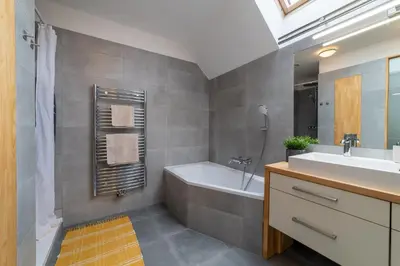 a bathroom with a tub and a sink and a bath tub at TinyGreens B & B in Poděbrady