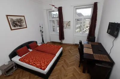 a bedroom with a bed and a table and window at Carpe Diem Prague in Prague