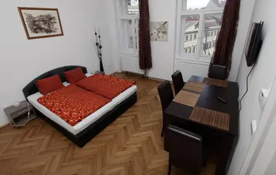 a bedroom with a bed and a table and a desk at Carpe Diem Prague in Prague