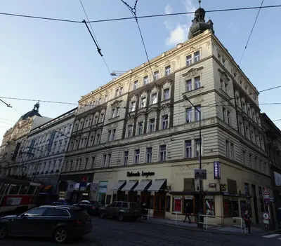 a large building on a street with cars parked in front at Carpe Diem Prague in Prague