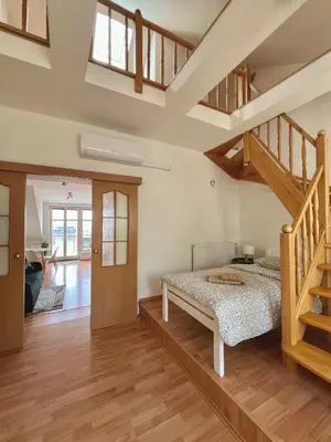 a bedroom with a bed and a staircase at Rooftop Prague view apartment in Prague