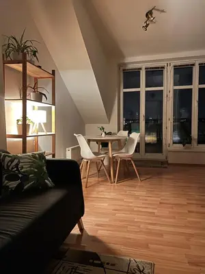 a living room with a couch and a table with chairs at Rooftop Prague view apartment in Prague