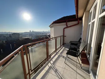 a balcony with two chairs and a view of the city at Rooftop Prague view apartment in Prague