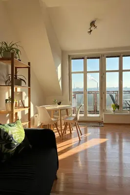 a living room with a couch and a table with chairs at Rooftop Prague view apartment in Prague