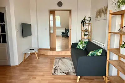 a living room with a couch and a television at Rooftop Prague view apartment in Prague