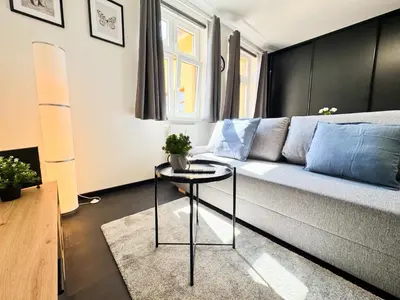 a living room with a couch and a table at A comfy apartment in Smíchov - Anděl in Prague