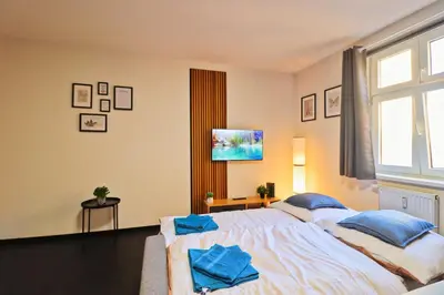 a bedroom with a large white bed with blue pillows at A comfy apartment in Smíchov - Anděl in Prague