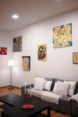 a living room with a couch and paintings on the wall at PavlaCzech Art Apartment in Prague