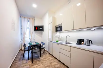 a kitchen with white cabinets and a table with chairs at PavlaCzech Art Apartment in Prague