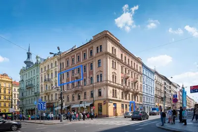 a building on a busy city street with people crossing the street at PavlaCzech Art Apartment in Prague