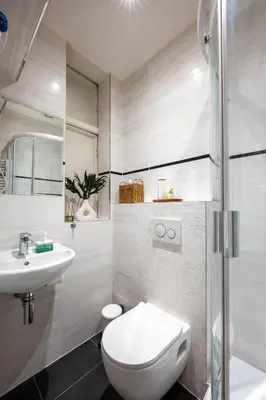 a white bathroom with a toilet and a sink at PavlaCzech Art Apartment in Prague