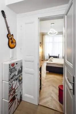 a room with a door leading to a bedroom with a guitar at Royal Charlie Suite in Prague