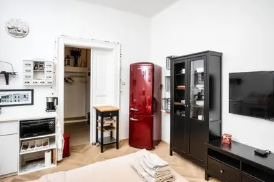 a living room with a red refrigerator and a tv at Royal Charlie Suite in Prague