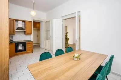 a kitchen and dining room with a wooden table and chairs at Royal Charlie Suite in Prague