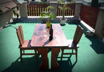 a wooden table with two chairs on a patio at Apartment Patera in Unhošť