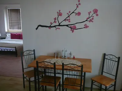 a dining room table with a tree with pink flowers on it at Apartment Patera in Unhošť