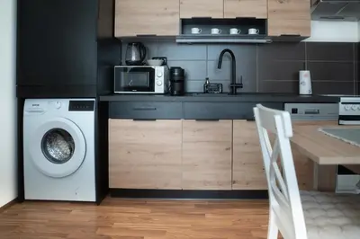 a kitchen with a washing machine and a microwave at Apartmán Slunce in Poděbrady