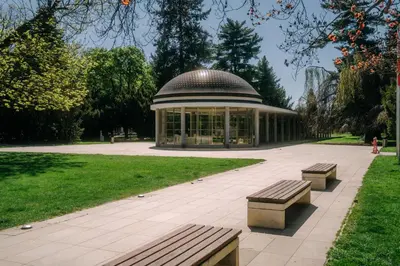 a building with two benches in a park at Apartmán Slunce in Poděbrady
