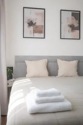 a white bed with two white towels on it at Apartmán Slunce in Poděbrady
