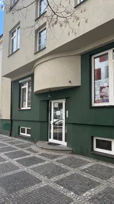 a green building with white doors and windows at Apartmán Slunce in Poděbrady
