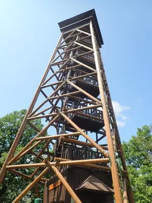 a tall wooden structure with trees in the background at Útulný apartmán na Slapech in Čím