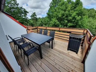 a deck with a table and chairs and a grill at Útulný apartmán na Slapech in Čím
