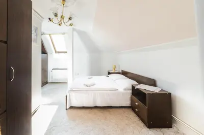 a bedroom with a white bed and a wooden dresser at Hotel Bohemia in Stará Boleslav