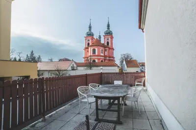 a table and chairs on a balcony with a church at Hotel Bohemia in Stará Boleslav