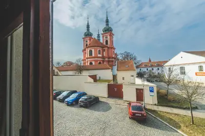 a group of cars parked in a parking lot in front of a church at Hotel Bohemia in Stará Boleslav