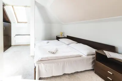 a white bedroom with a large bed and a window at Hotel Bohemia in Stará Boleslav