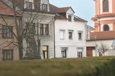 a building with a statue in front of it at Hotel Bohemia in Stará Boleslav