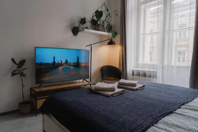 a bedroom with a flat screen tv on a bed at Cozy warm studio in Prague city center in Prague